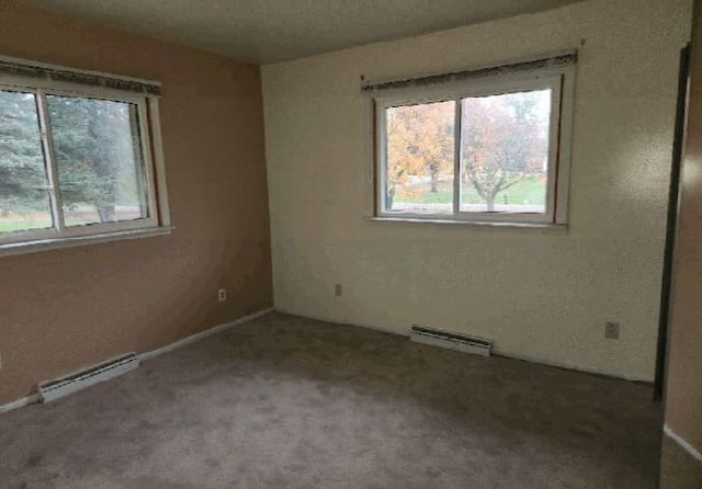 carpeted spare room with baseboard heating