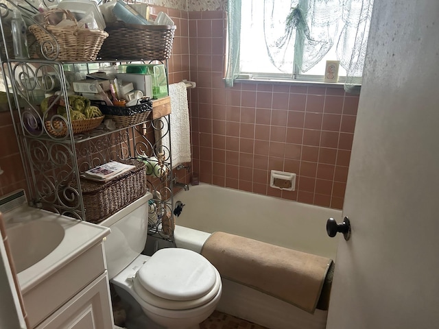 full bathroom featuring vanity, tiled shower / bath combo, and toilet