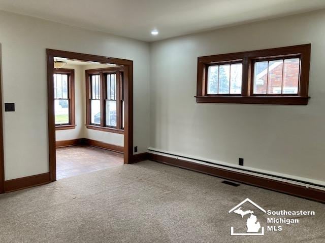 carpeted spare room with baseboard heating and ceiling fan