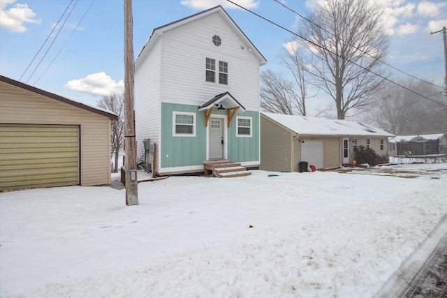 view of property featuring a garage and an outbuilding