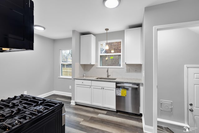 kitchen with light stone counters, sink, dishwasher, white cabinetry, and hanging light fixtures