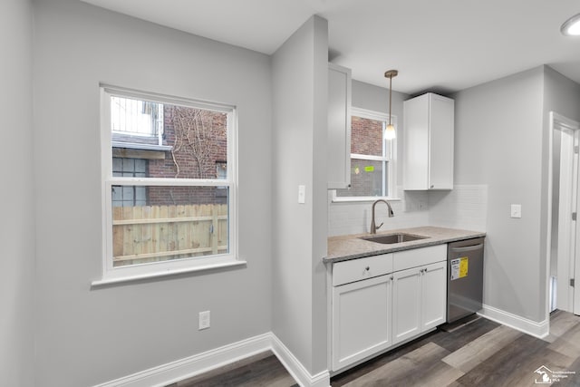 kitchen featuring dishwasher, pendant lighting, tasteful backsplash, and white cabinetry