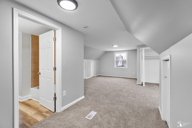 bonus room featuring light colored carpet and lofted ceiling