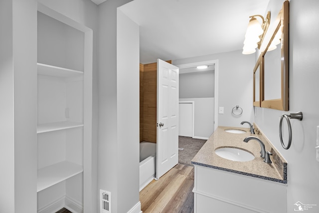 bathroom featuring vanity,  shower combination, and wood-type flooring