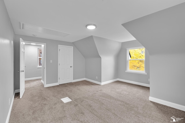 bonus room with carpet floors and vaulted ceiling