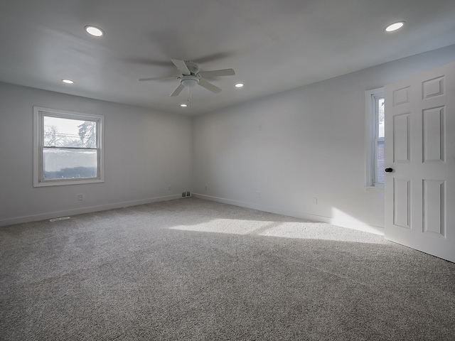 carpeted spare room with ceiling fan and a wealth of natural light