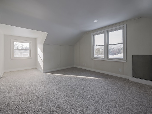 bonus room featuring lofted ceiling and light colored carpet