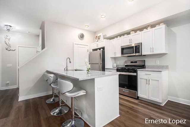 kitchen featuring white cabinets, light stone countertops, sink, and appliances with stainless steel finishes