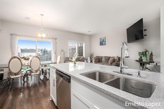 kitchen with white cabinetry, sink, light stone countertops, hanging light fixtures, and stainless steel dishwasher