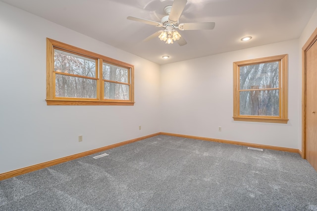 carpeted spare room with ceiling fan