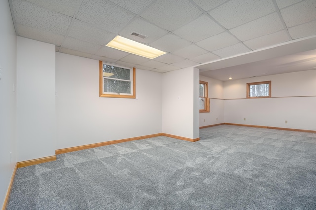 basement featuring a paneled ceiling and carpet