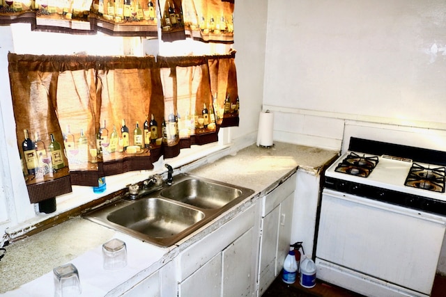 kitchen featuring white gas range and sink