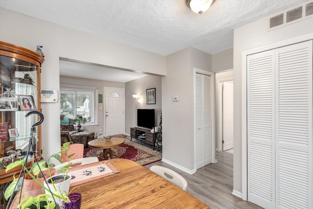 living room with a textured ceiling and light wood-type flooring