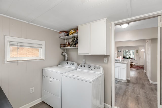 washroom featuring cabinets, hardwood / wood-style flooring, and washer and dryer