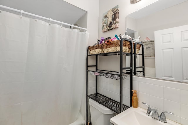 bathroom featuring decorative backsplash, toilet, and sink