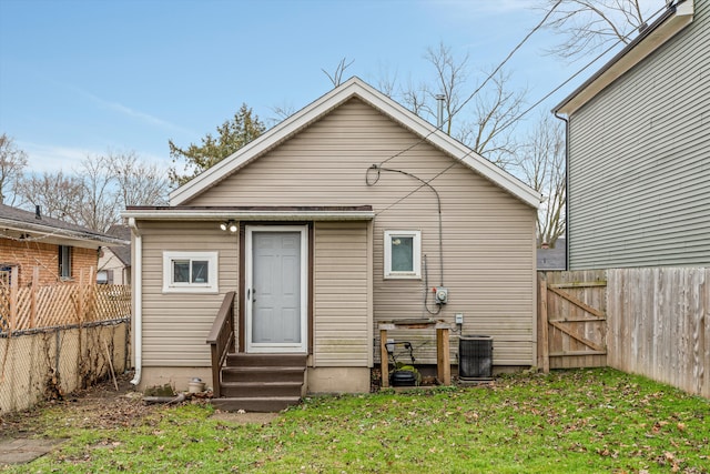 back of house featuring cooling unit and a yard