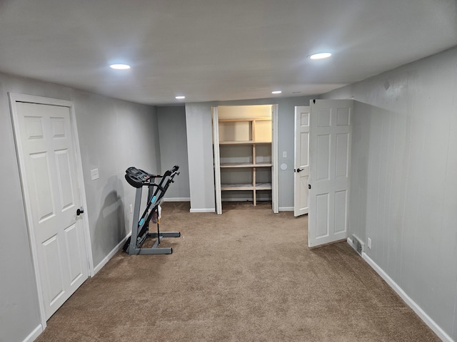 exercise room featuring light carpet