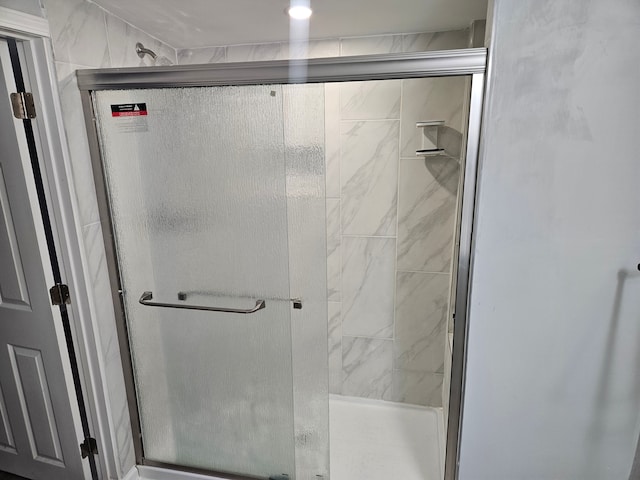 bathroom with a shower with door