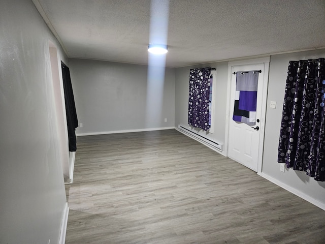 spare room featuring a baseboard radiator, a textured ceiling, and hardwood / wood-style flooring