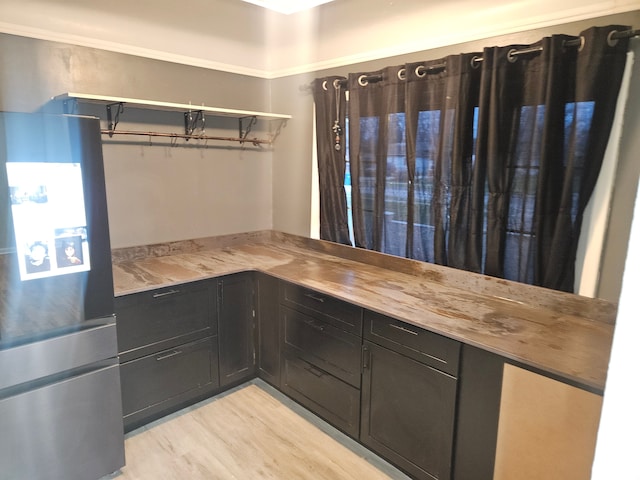 kitchen featuring stainless steel fridge and light hardwood / wood-style flooring