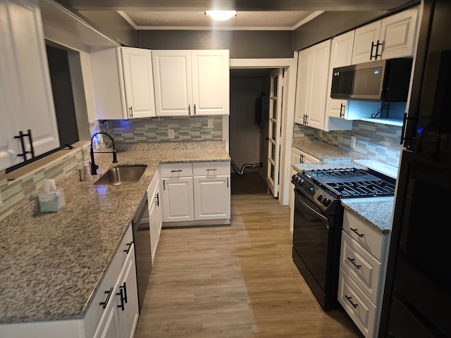 kitchen with black appliances, white cabinets, sink, decorative backsplash, and light stone countertops