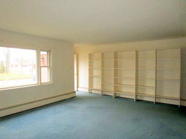 carpeted empty room featuring a baseboard heating unit