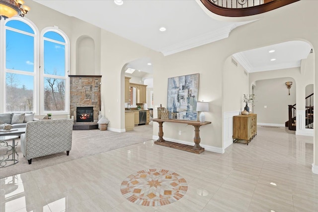 interior space featuring ornamental molding, a fireplace, and a high ceiling