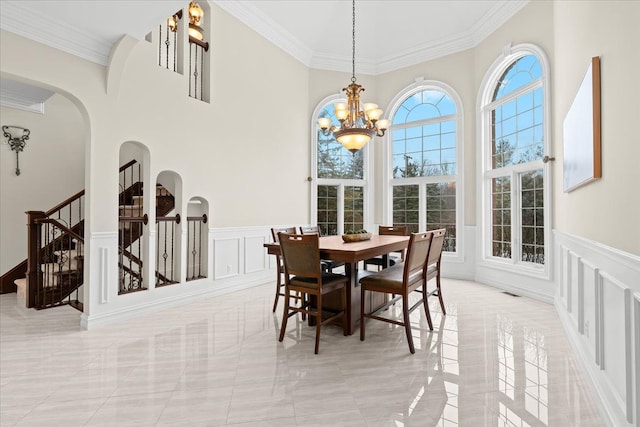 dining space featuring crown molding and a notable chandelier