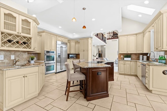 kitchen with a kitchen breakfast bar, a kitchen island, backsplash, and appliances with stainless steel finishes