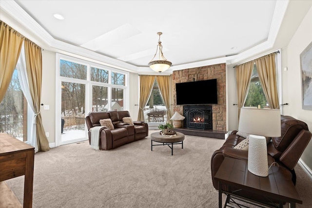 living room with carpet flooring, a healthy amount of sunlight, a raised ceiling, and a fireplace