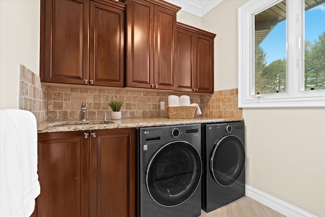 washroom featuring cabinets, sink, crown molding, washing machine and dryer, and a wealth of natural light