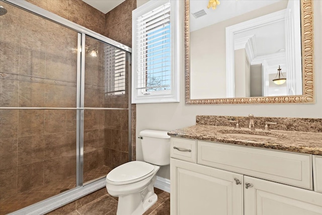 bathroom with vanity, toilet, and a shower with shower door