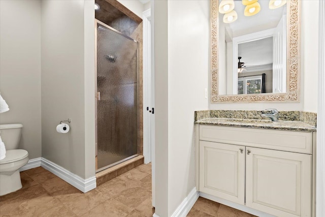 bathroom featuring vanity, toilet, a shower with door, and ceiling fan