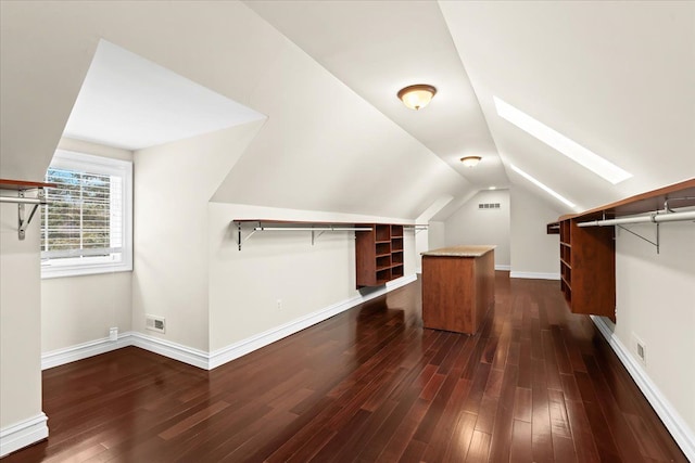 walk in closet featuring vaulted ceiling with skylight and dark hardwood / wood-style floors