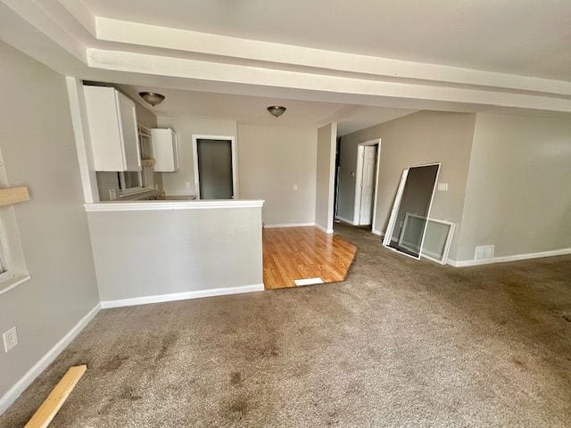 carpeted spare room featuring baseboards