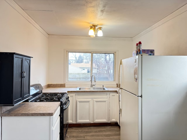 kitchen featuring white cabinetry, sink, an inviting chandelier, white fridge, and black range with gas cooktop