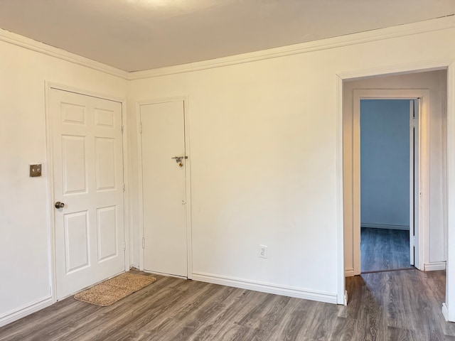 spare room featuring dark hardwood / wood-style floors and crown molding