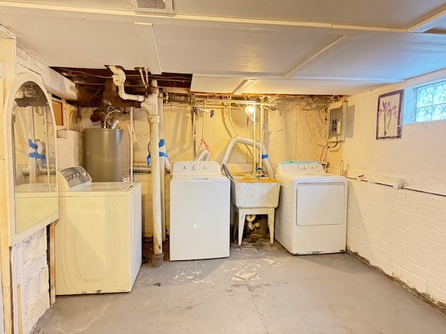 clothes washing area featuring gas water heater, separate washer and dryer, sink, and electric panel