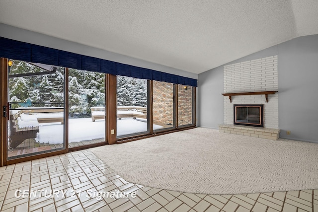 unfurnished living room featuring a fireplace, a textured ceiling, and vaulted ceiling