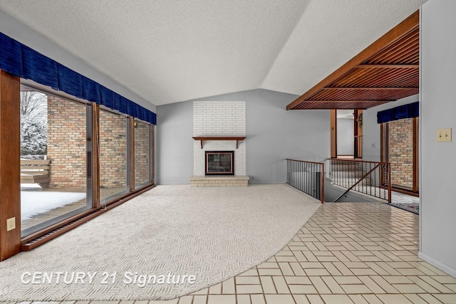 unfurnished living room featuring a textured ceiling, a fireplace, carpet, and lofted ceiling