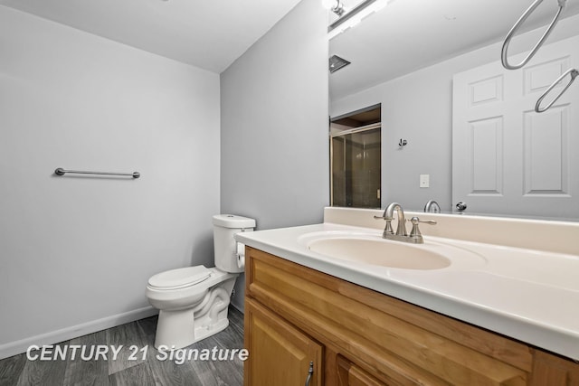 bathroom featuring toilet, an enclosed shower, and vanity