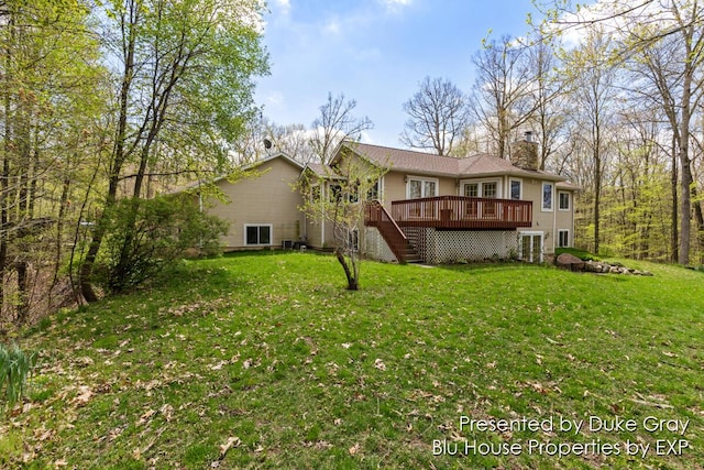 back of property featuring a deck and a lawn