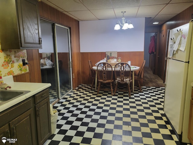 dining area with an inviting chandelier, a drop ceiling, and sink