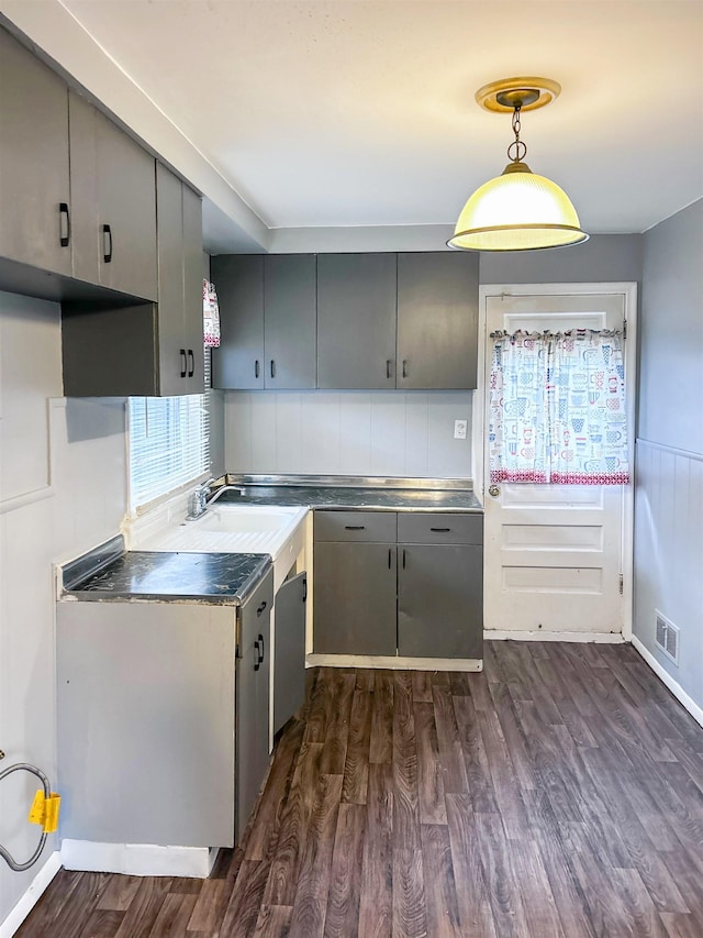 kitchen with backsplash, gray cabinetry, sink, pendant lighting, and dark hardwood / wood-style floors