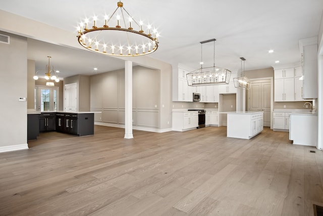 kitchen featuring pendant lighting, white cabinetry, stainless steel appliances, and a kitchen island