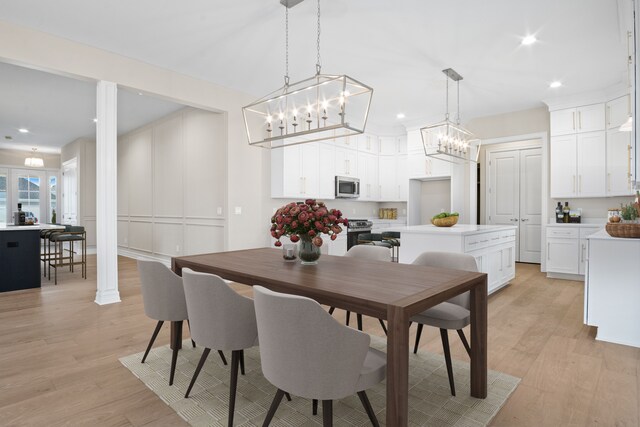 54673 Ann Dr, Macomb, MI 48042 - dining room with an inviting chandelier, a decorative wall, light wood-style floors, and recessed lighting
