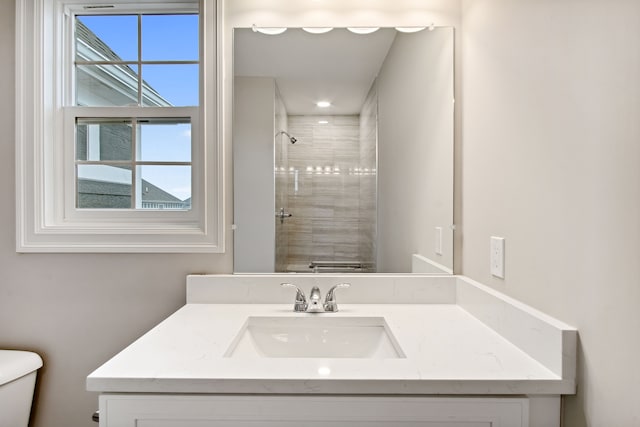 bathroom featuring vanity, toilet, and a shower with door