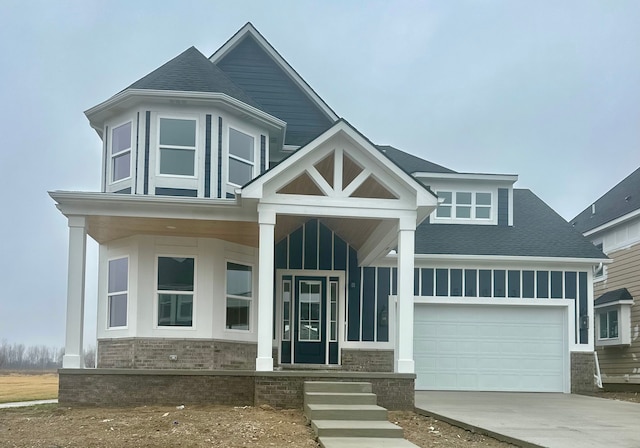 54673 Ann Dr, Macomb, MI 48042 - view of front of property featuring board and batten siding, concrete driveway, a garage, and a shingled roof