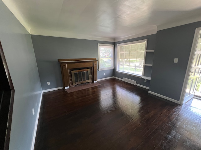 unfurnished living room featuring dark hardwood / wood-style flooring and a brick fireplace