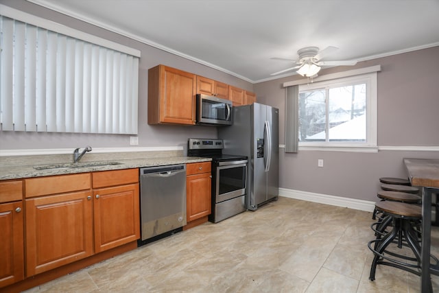 kitchen featuring light stone counters, ornamental molding, stainless steel appliances, ceiling fan, and sink